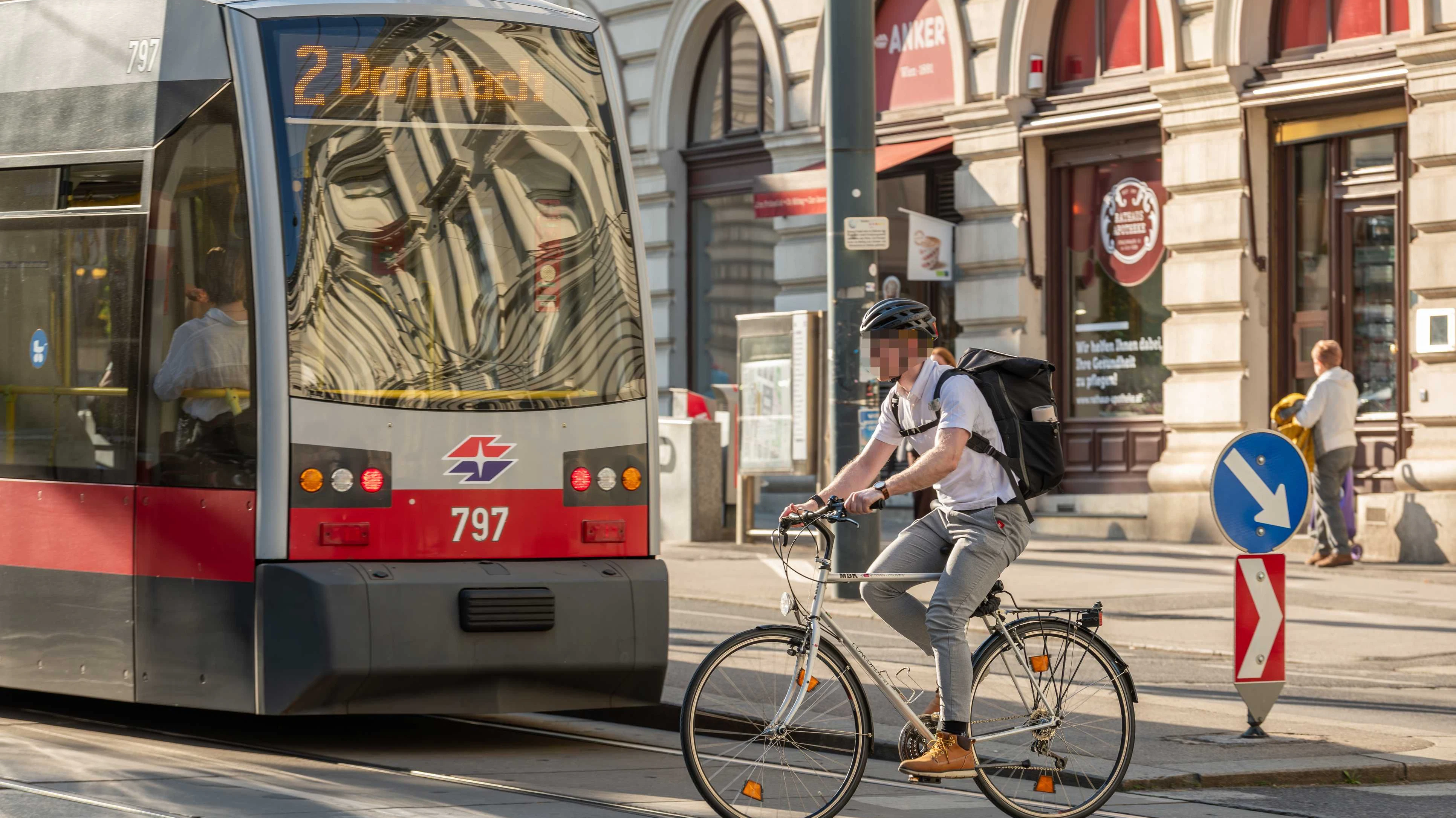 Vienna, Austria. A cyclist riding alongside a tram on a city street, illustrating sustainable urban mobility, commuting, and multimodal transport in a European capital.