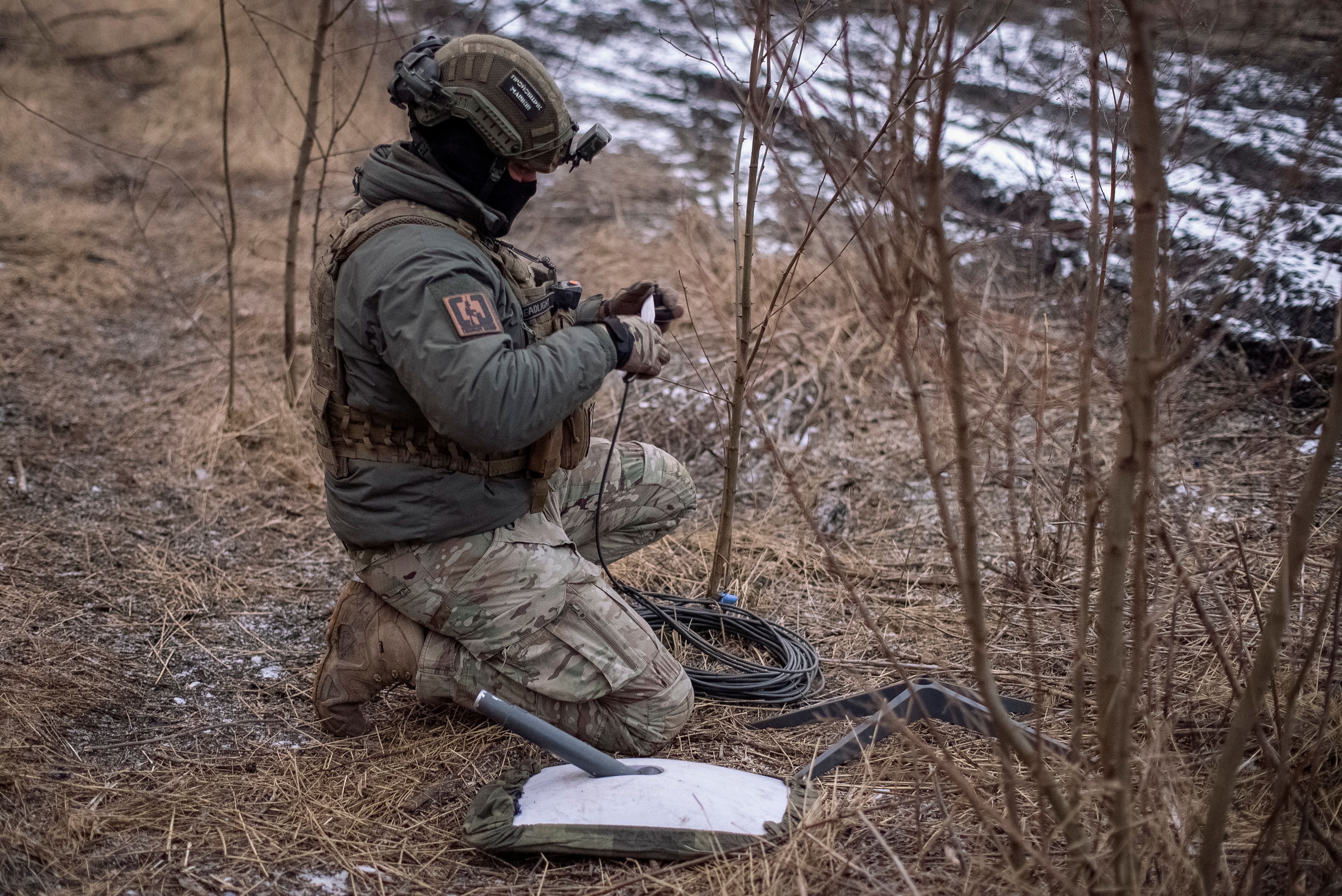 Ein ukrainischer Soldat der 47. Brigade bereitet an seiner Frontstellung ein Starlink-Satelliten-Internetsystem vor: