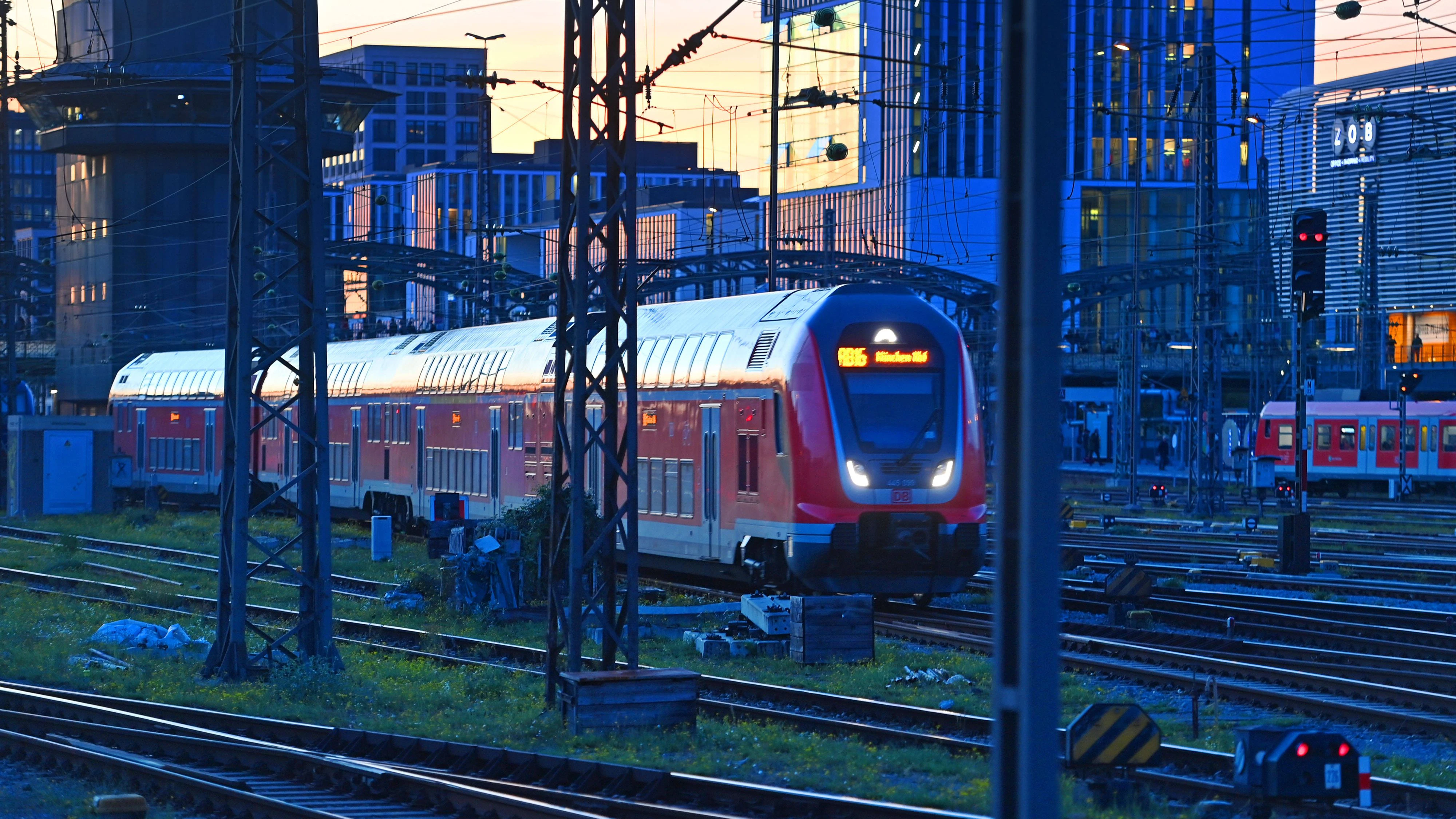 Ein roter Doppelstock-Regionalzug der Deutschen Bahn im Gleisvorfeld des Münchner Hauptbahnhofs vor der Hackerbrücke.