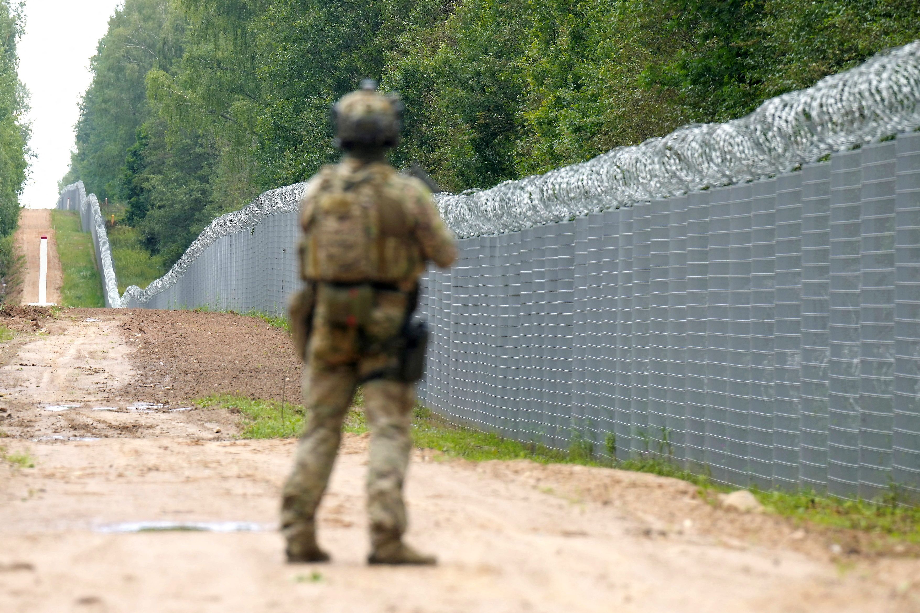 Ein Beamter der lettischen Spezialeinheit der Grenzschutzbehörde patrouilliert entlang des Zauns an der lettisch-weißrussischen Grenze in der Nähe von Robeznieki. Archivbild, August 2023