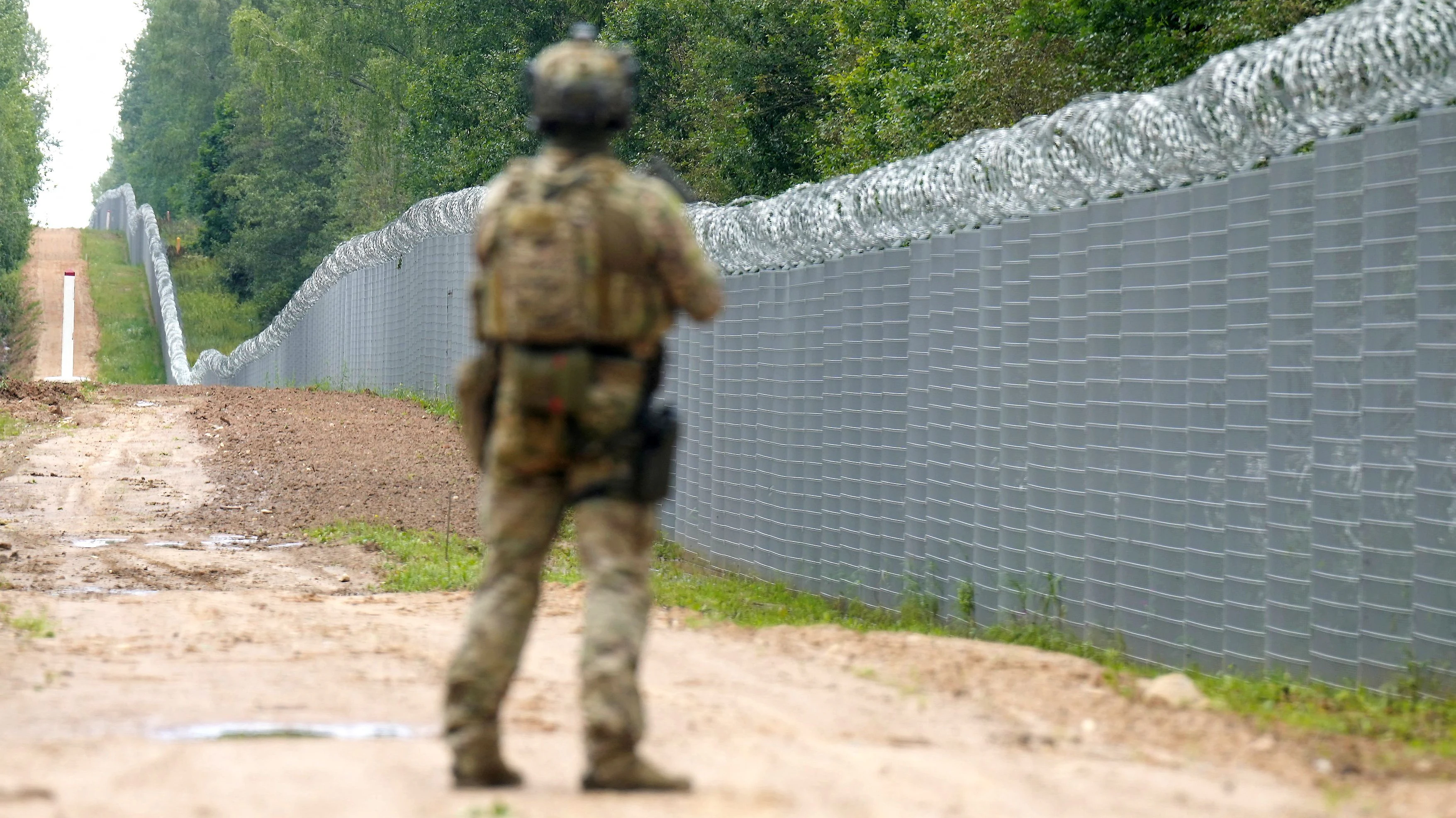Ein Beamter der lettischen Spezialeinheit der Grenzschutzbehörde patrouilliert entlang des Zauns an der lettisch-weißrussischen Grenze in der Nähe von Robeznieki. Archivbild, August 2023
