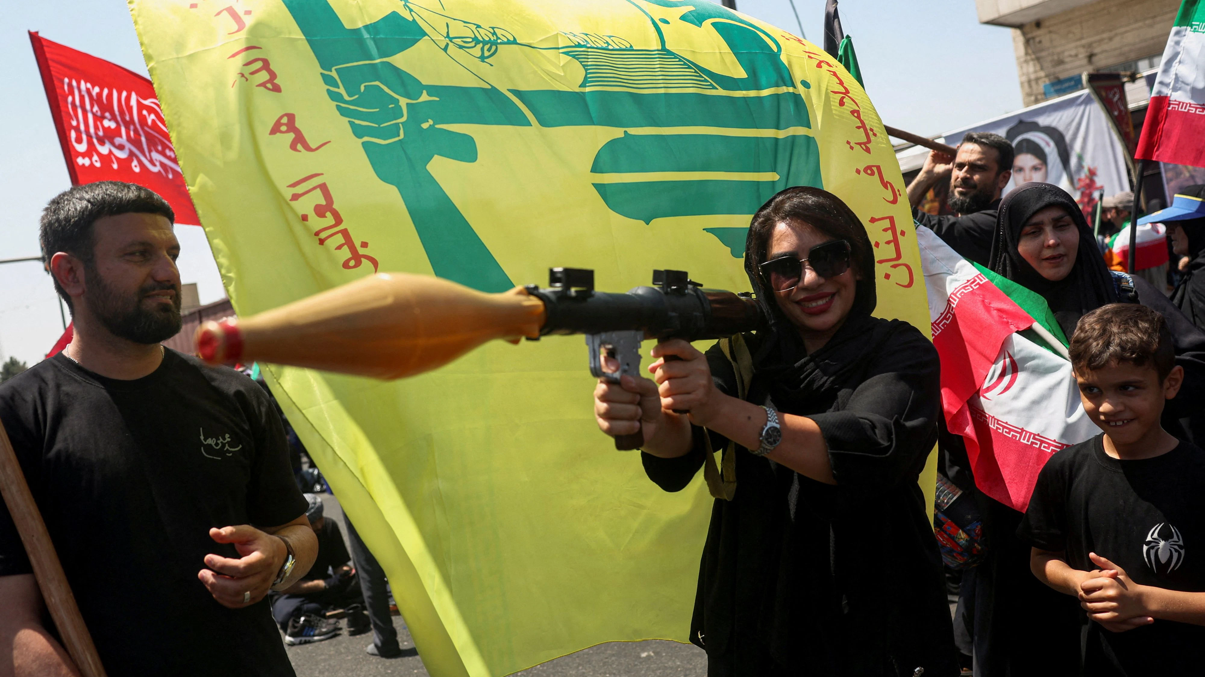 A woman holds a mock-up of a rocket-propelled grenade (RPG) next to a Hezbollah flag during the Arbaeen rally in Tehran, Iran, August 4, 2026. Majid Asgaripour/WANA (West Asia News Agency) via REUTERS ATTENTION EDITORS - THIS PICTURE WAS PROVIDED BY A THIRD PARTY. ISRAEL OUT. NO COMMERCIAL OR EDITORIAL SALES IN ISRAEL. NO ACCESS FOR ISRAELI MEDIA. NO USE BBC PERSIAN. NO USE VOA PERSIAN. NO USE MANOTO. NO USE IRAN INTERNATIONAL. NO USE RADIO FARDA. DIGITAL: NO USE BBC PERSIAN. NO USE VOA PERSIAN. NO USE MANOTO. NO USE IRAN INTERNATIONAL. NO USE RADIO FARDA. ISRAEL OUT. NO COMMERCIAL OR EDITORIAL SALES IN ISRAEL     TPX IMAGES OF THE DAY     
