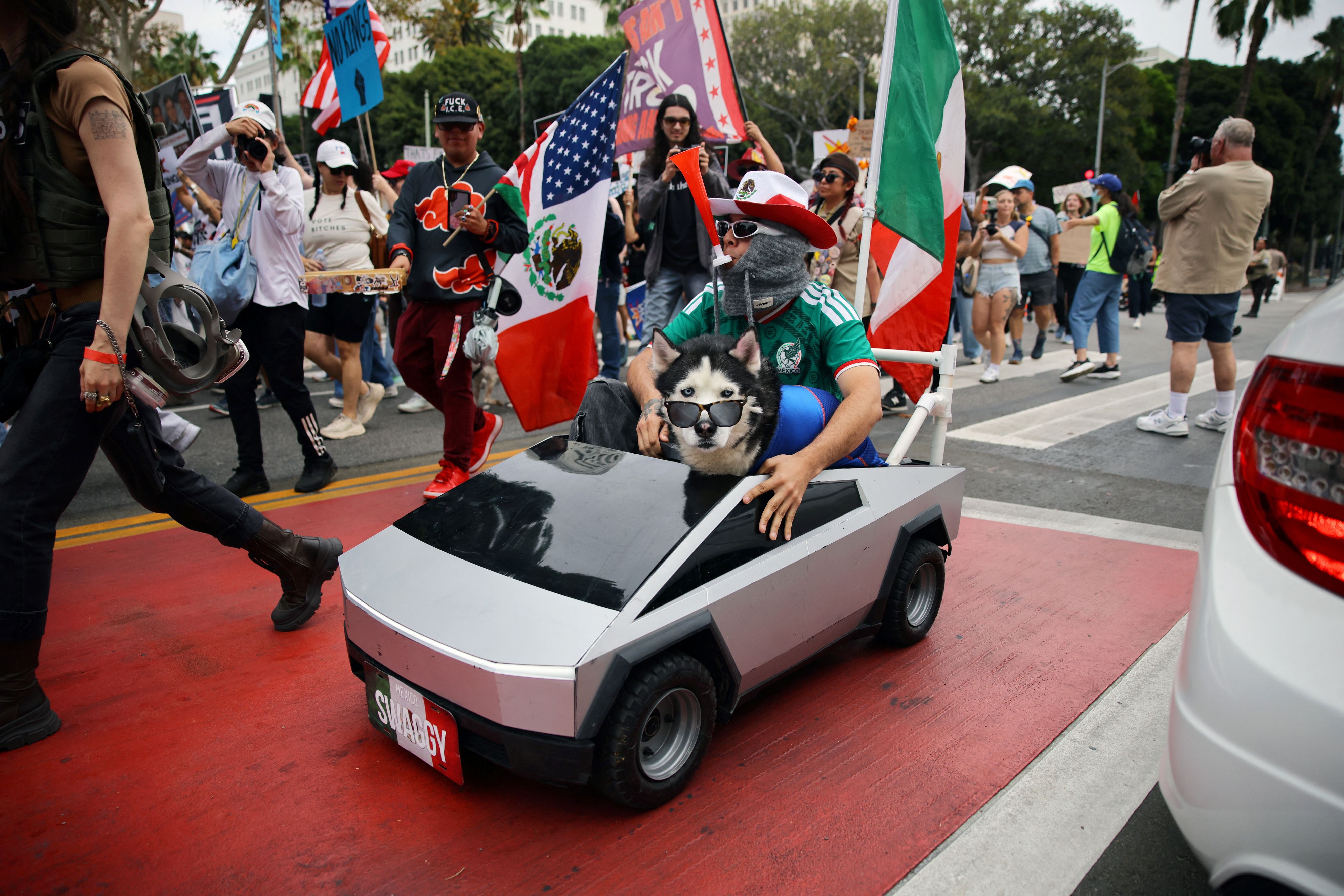 Ein Demonstrant und ein Hund fahren auf einem Modell eines Tesla Cybertrucks mit – während eines 