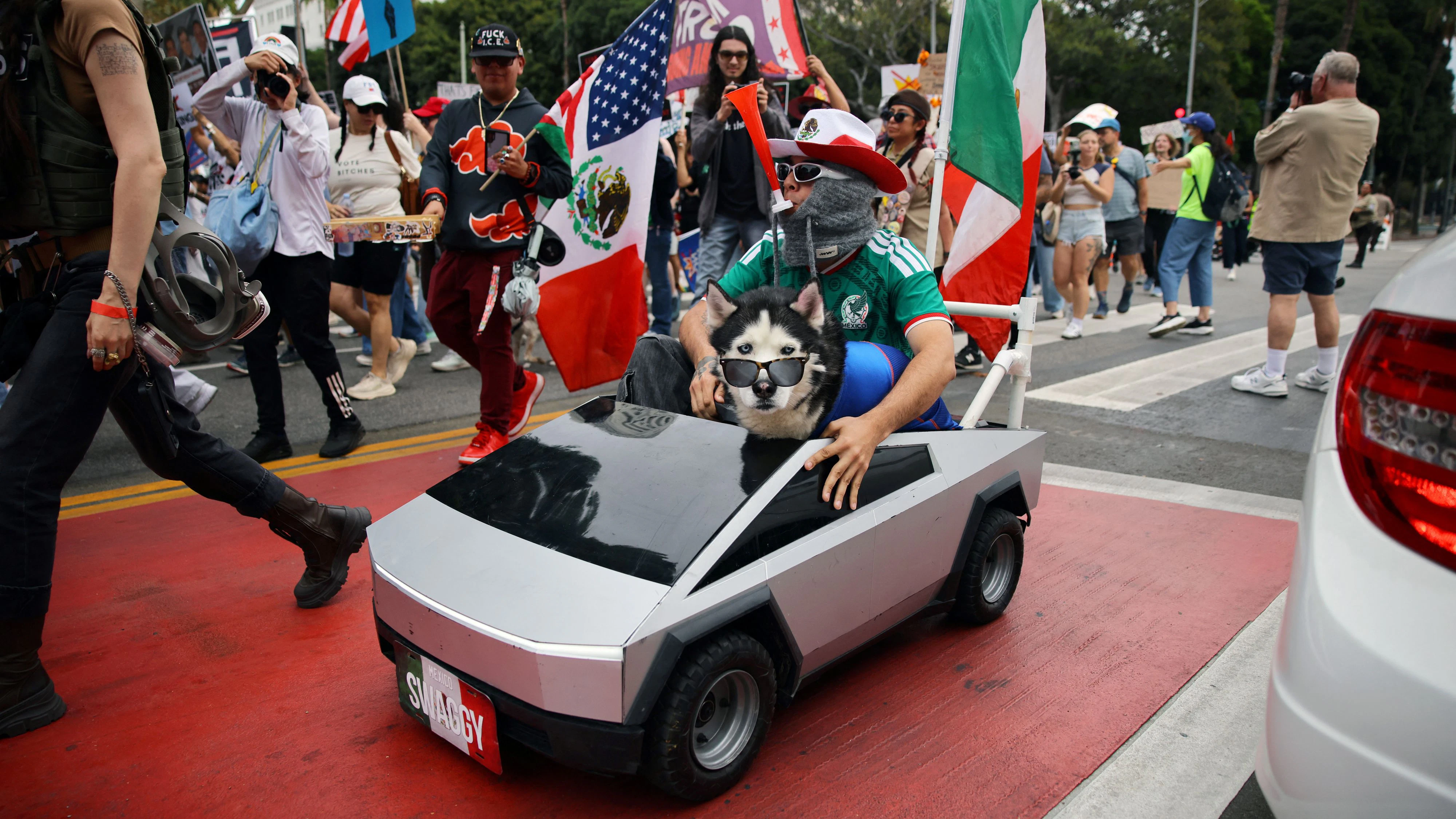 A demonstrator and a dog ride on a Tesla Cybertruck mockup during a "No Kings" protest, part of a nationwide day of action aimed at encouraging early voting ahead of the US midterm elections, in Los Angeles, California, US, October 17, 2026. REUTERS/Daniel Cole     TPX IMAGES OF THE DAY     