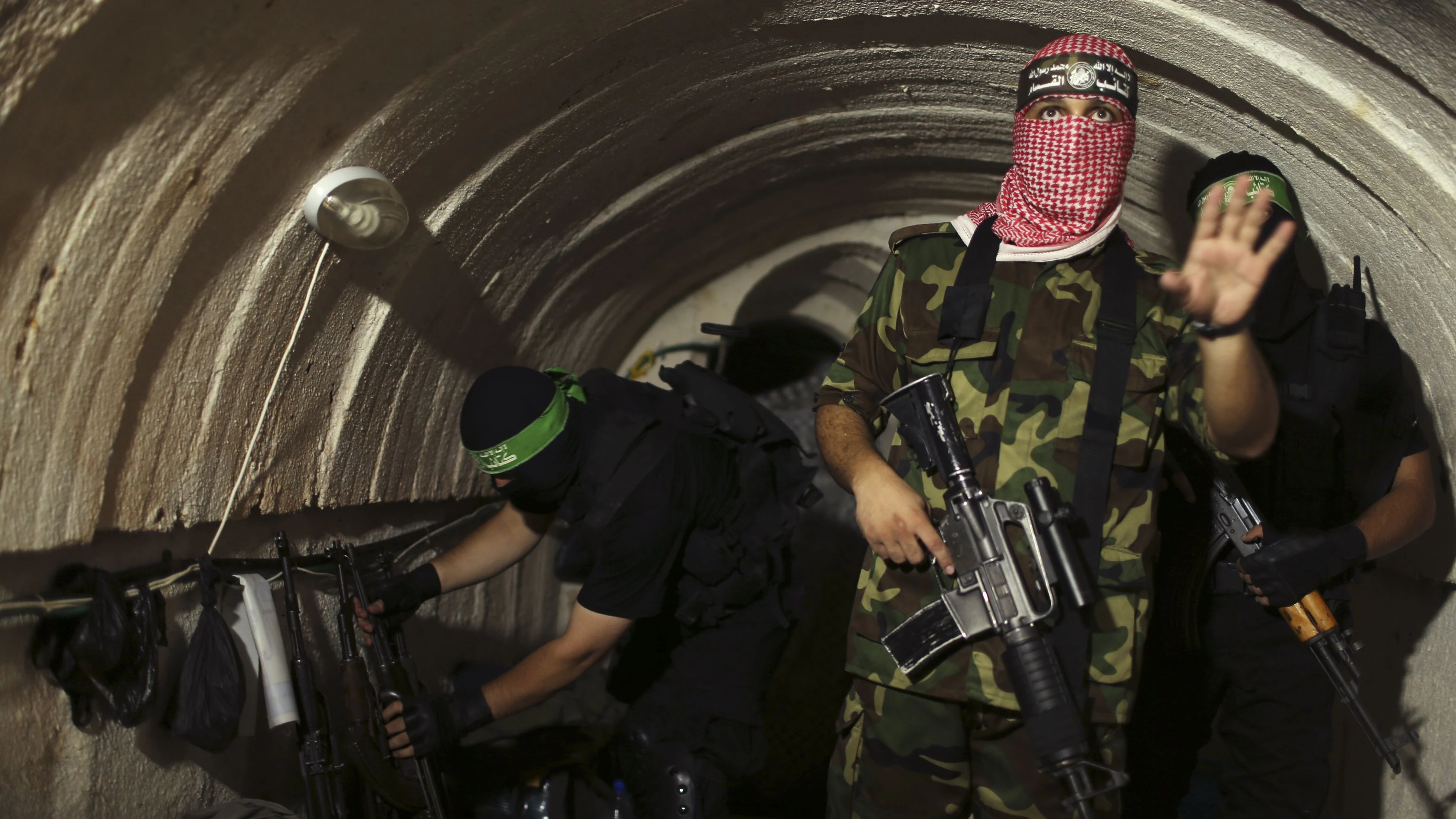 A Palestinian fighter from the Izz el-Deen al-Qassam Brigades, the armed wing of the Hamas movement, gestures inside an underground tunnel in Gaza August 18, 2014. A rare tour that Hamas granted to a Reuters reporter, photographer and cameraman appeared to be an attempt to dispute Israel's claim that it had demolished all of the Islamist group's border infiltration tunnels in the Gaza war. Picture taken August 18, 2014. REUTERS/Mohammed Salem (GAZA - Tags: POLITICS CONFLICT TPX IMAGES OF THE DAY)