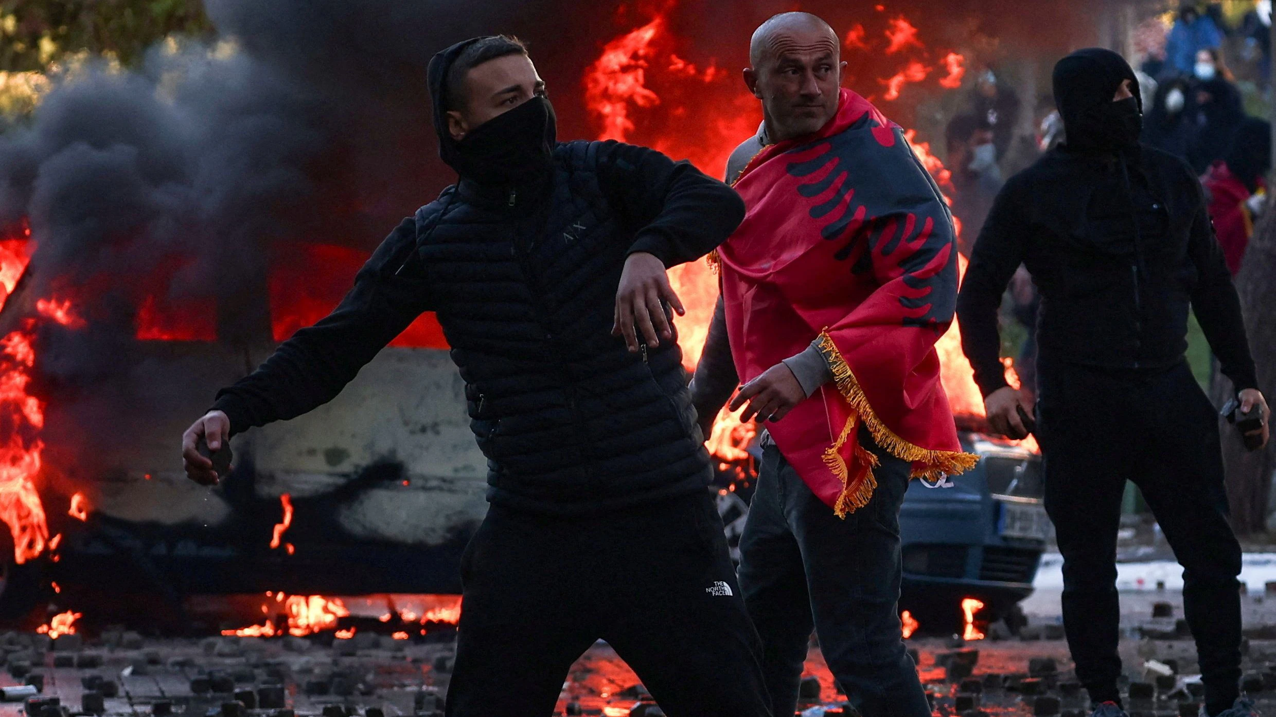A demonstrator covered with an Albanian national flag looks on as people clash with police amid an anti-government protest held by students, in Tirana, Albania, October 17, 2026. REUTERS/Florion Goga     TPX IMAGES OF THE DAY     