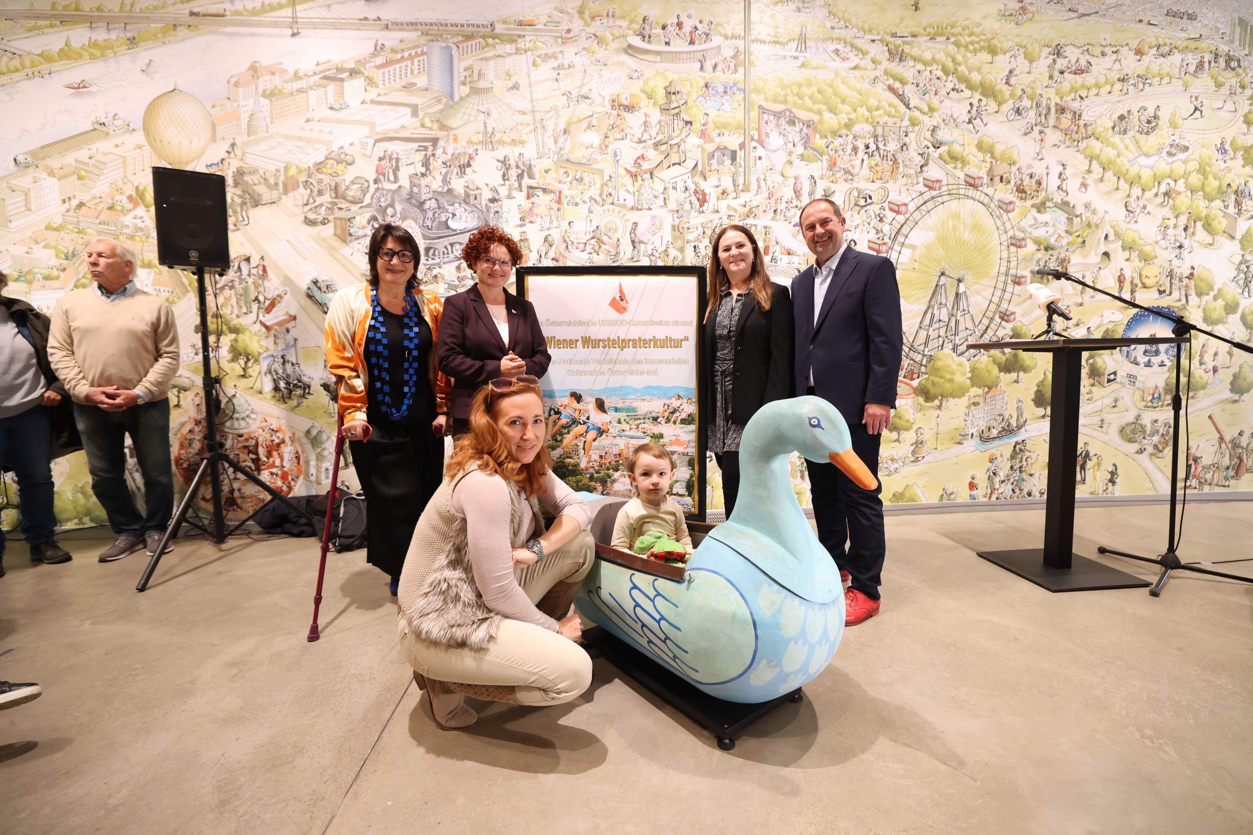 Kulturstadträtin Veronica Kaup-Hasler, Staatssekretärin Elisabeth Zehetner, Praterverbands-Präsidentin Silvia Lang, Bezirksvorsteher Nikolai (v. li.) und unten die nächste Generation einer bekannten Praterfamilie Karoline Brantusa und ihre Mama Kristina (u.a. Altwiener Grottenbahn).