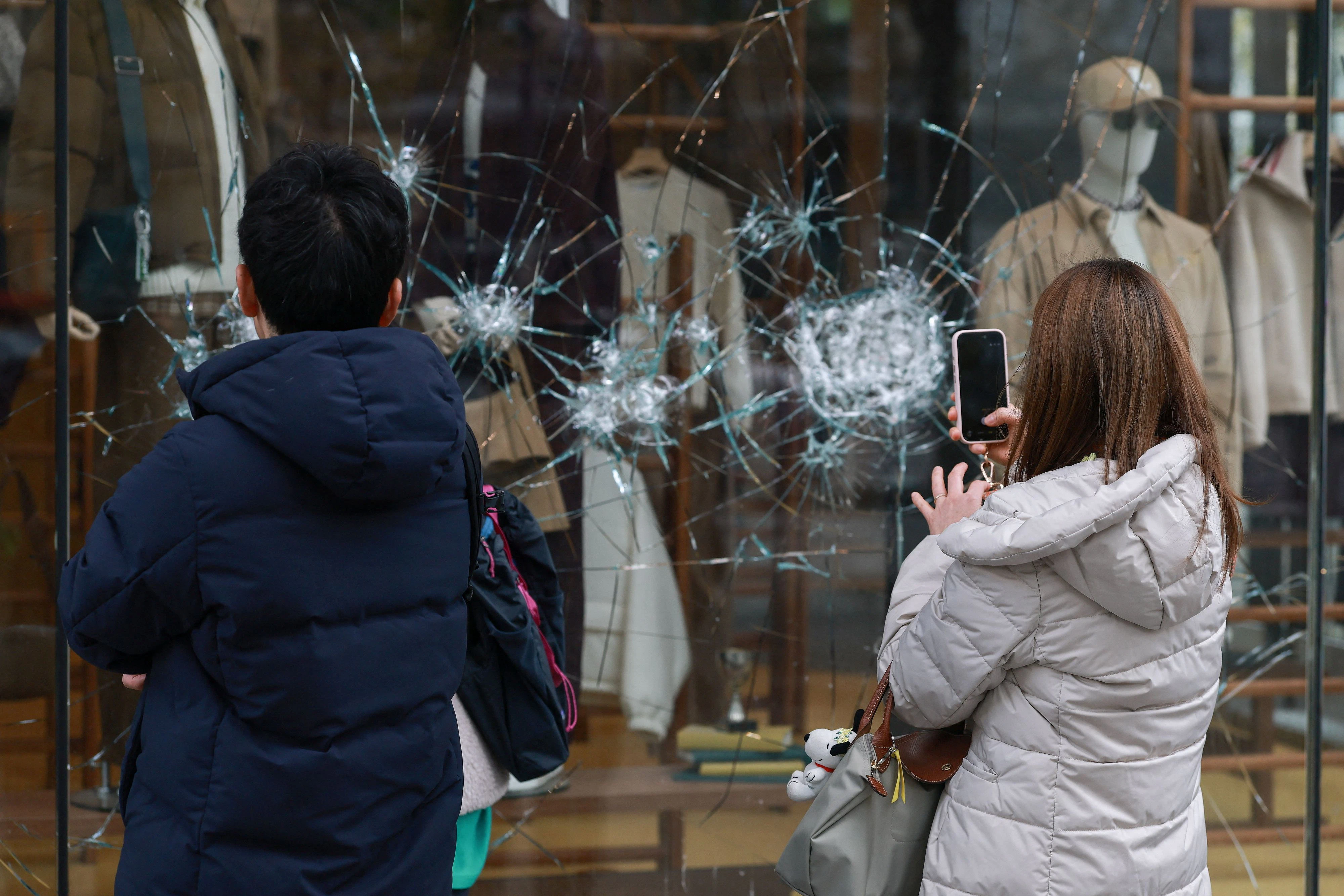 Aufstands-Sightseeing: Menschen fotografieren die Schäden der vorangegangenen Nacht an einer Boutique auf den Champs-Élysée in Paris