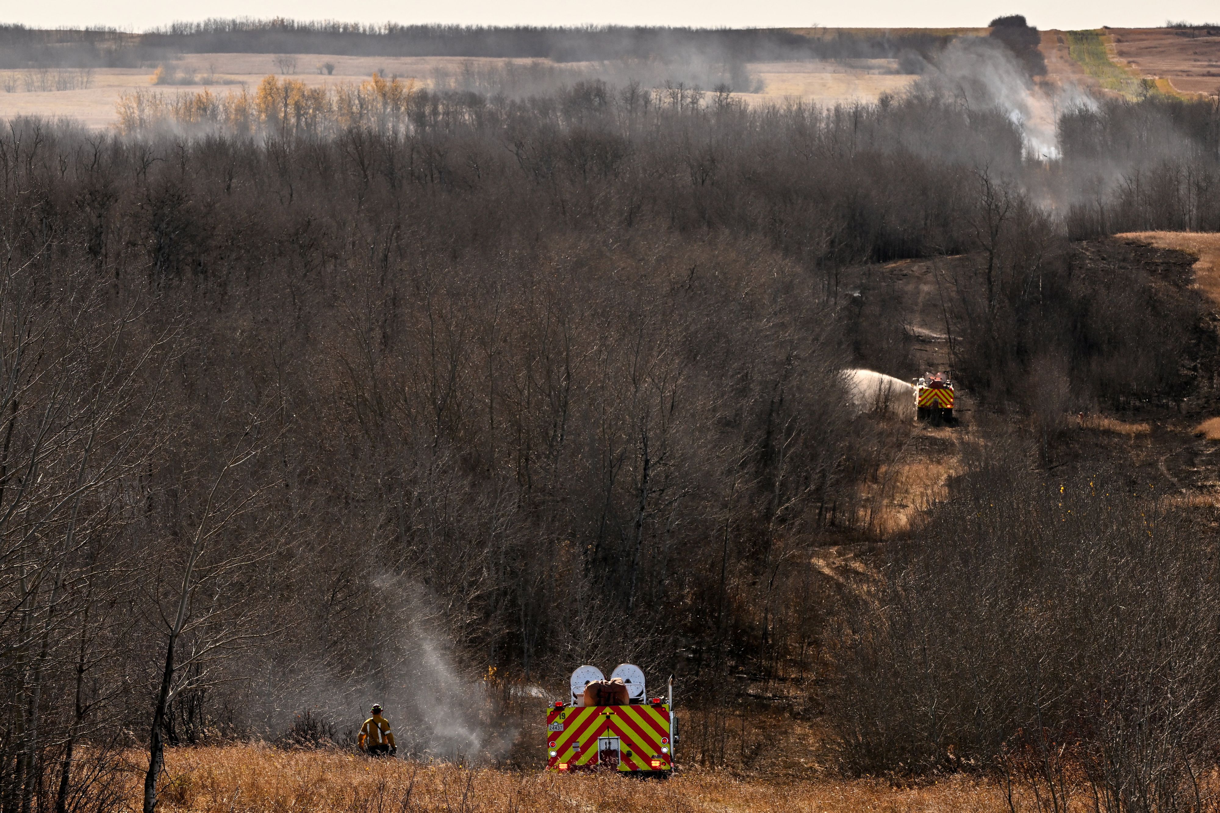 Feuerwehrleute sind auch am Tag nach einem schwerwiegenden Vorfall, bei dem ein Brand zu Todesfällen und Verletzungen führte, weiterhin mit der Bekämpfung von Glutnestern beschäftigt – in Wainwright, Alberta, Kanada, am 18. Oktober 2026. REUTERS/Jennifer Gauthier