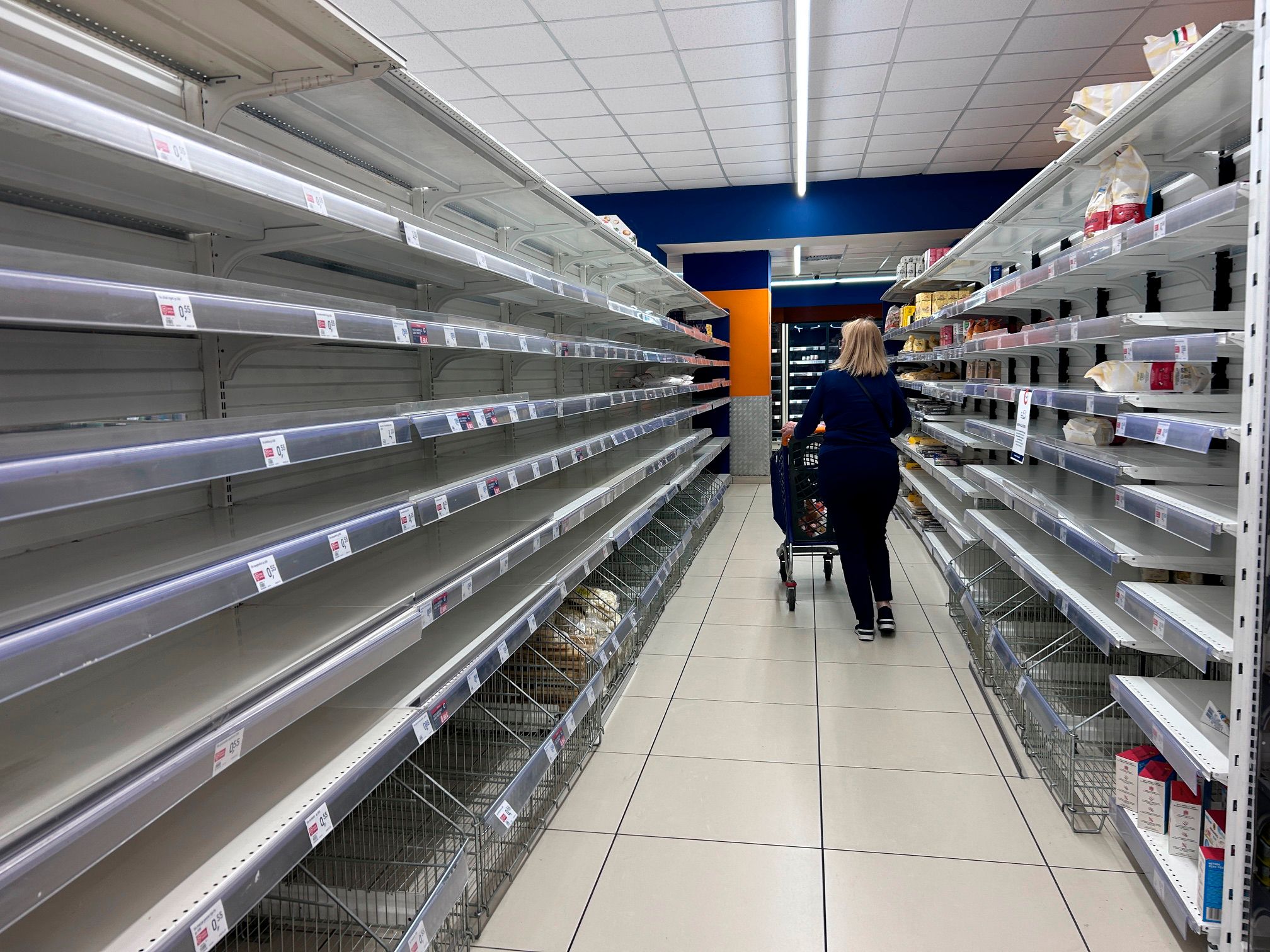 Eine Frau passiert leere Supermarktregale in Neapel am Dienstag, 20. Oktober 2026