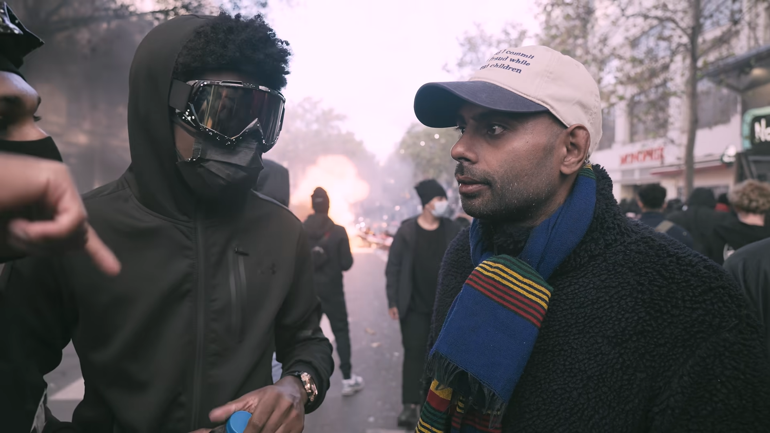 Gesicht verhüllt, Wut unverblümt: Mitten in den Krawallen von Paris spricht ein vermummter Demonstrant mit dem britischen YouTuber Aaron über die Proteste.
