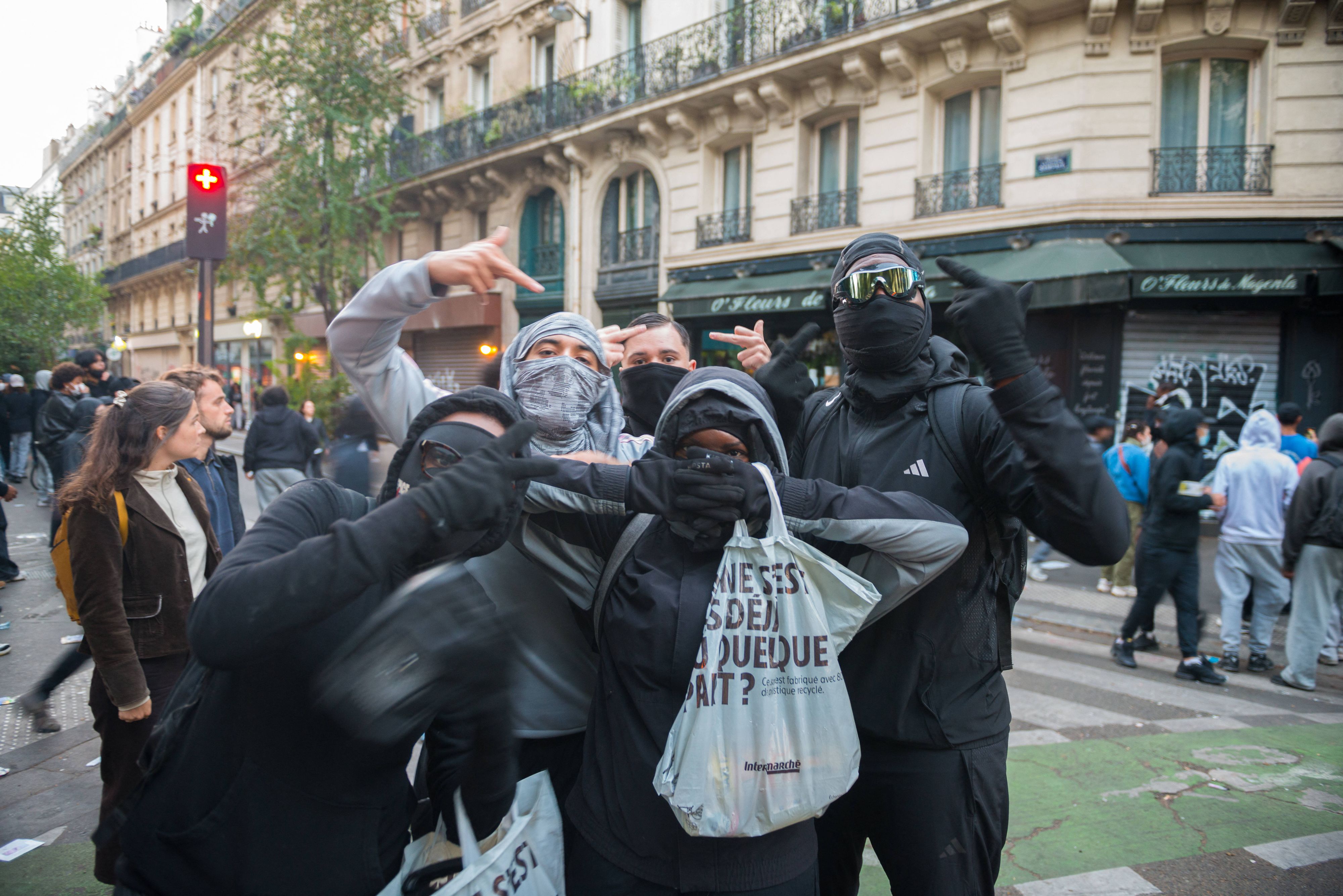 Vermummte mit Einkaufstaschen bei den heftigen Protesten am 17. Oktober 2026 in Paris. Nach den Plünderungen und Ausschreitungen fallen nun die ersten Gerichtsurteile.