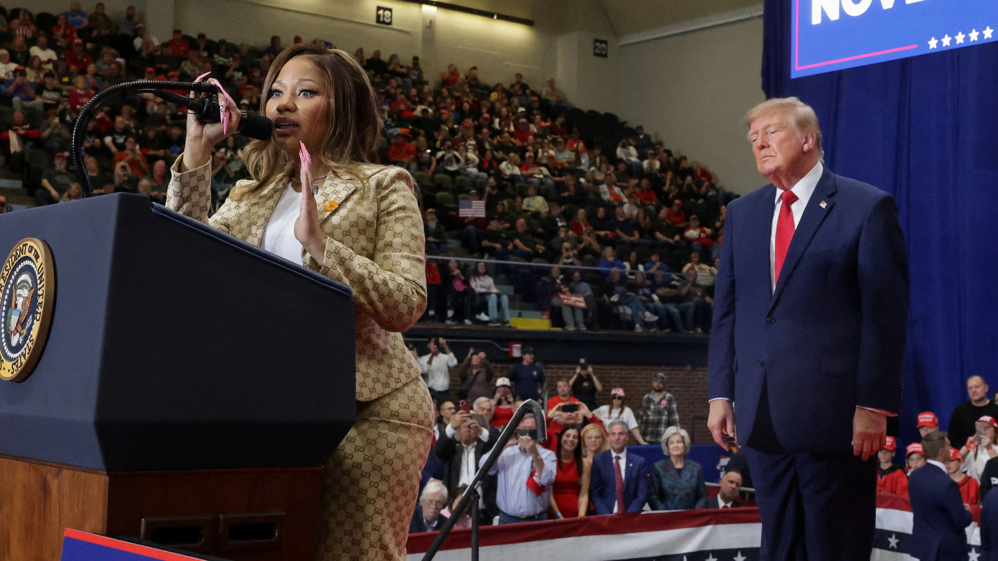 Recording artist Nicki Minaj speaks, as US President Donald Trump stands nearby, during a rally, in support of Republican US Senate candidate, former US Representative Mike Rogers, ahead of the midterm elections, at an entertainment complex in Port Huron, Michigan, US, October 25, 2026. REUTERS/Jonathan Ernst