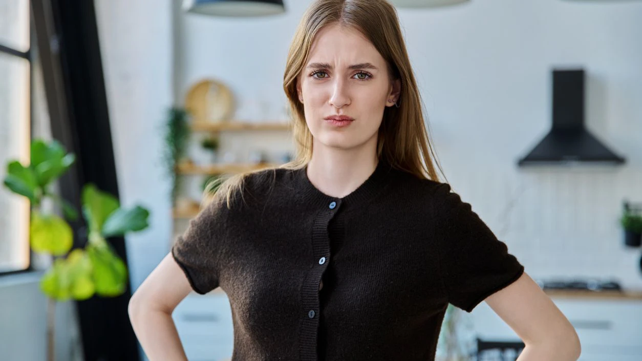Portrait of female teenager 17-19 years old, serious angry upset looking at camera in home interior. Emotions, mental health, lifestyle, youth concept
