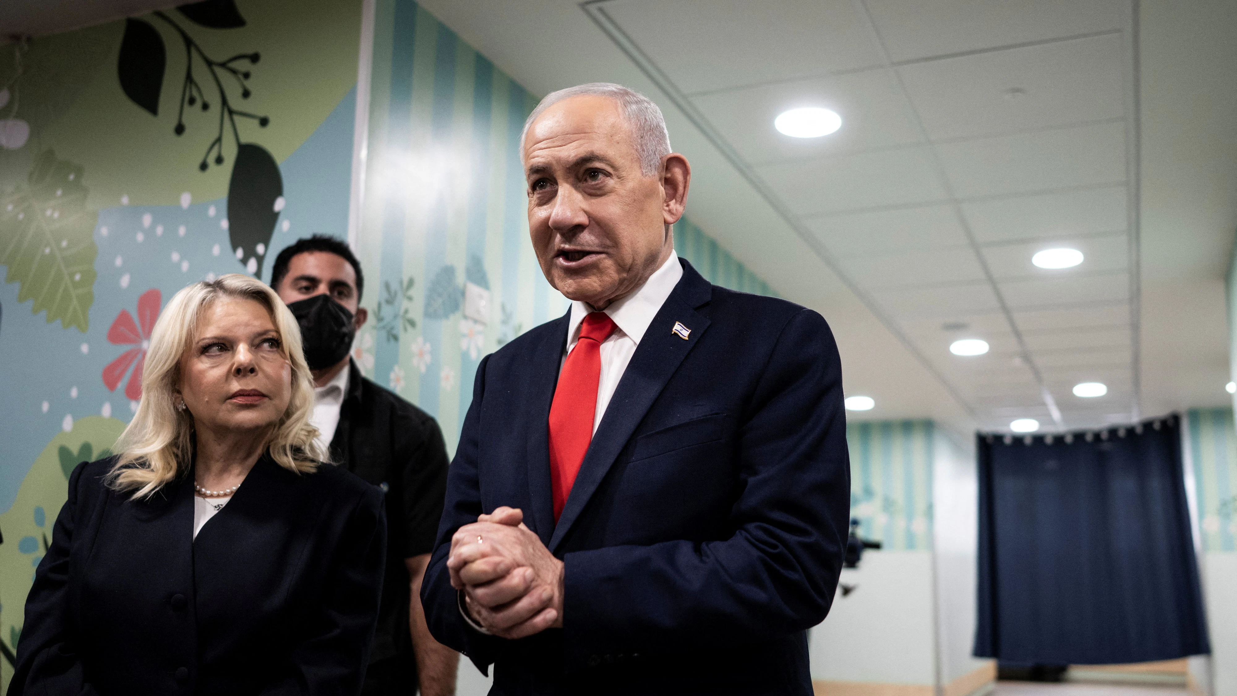 Israel's Prime Minister Benjamin Netanyahu speaks to the media as he stands next to his wife Sara after voting at a polling station in Jerusalem on October 27, 2026, on the day of Israel's legislative election.  JEWEL SAMAD/Pool via REUTERS