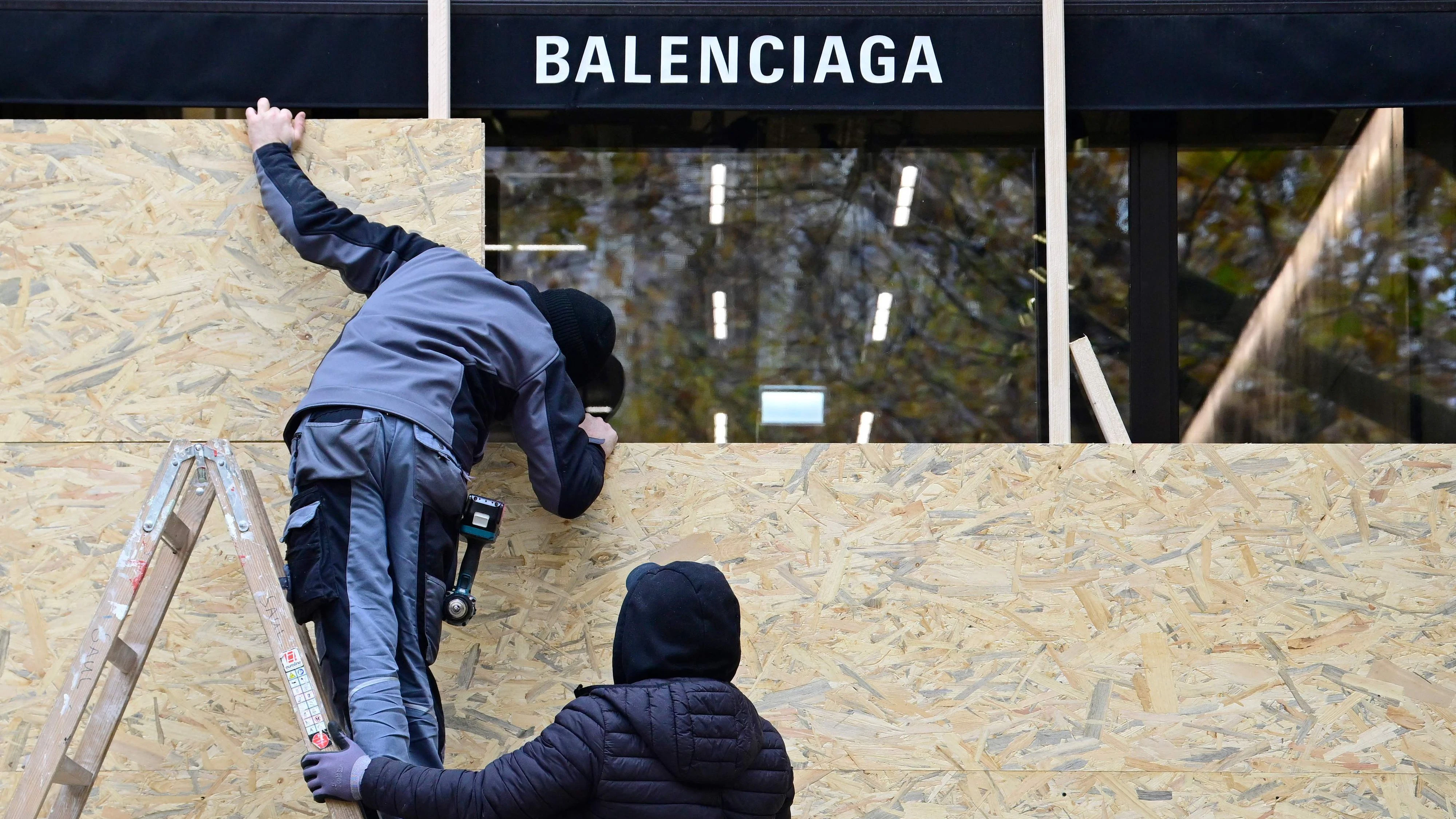 Am 30. Oktober 2026, einen Tag vor den angekündigten bundesweiten Jugenddemonstrationen, zu denen die Initiative "GenZ regelt" aufgerufen hatte, vernageln Arbeiter die Fenster einer Balenciaga-Filiale am Kurfürstendamm in Berlin.