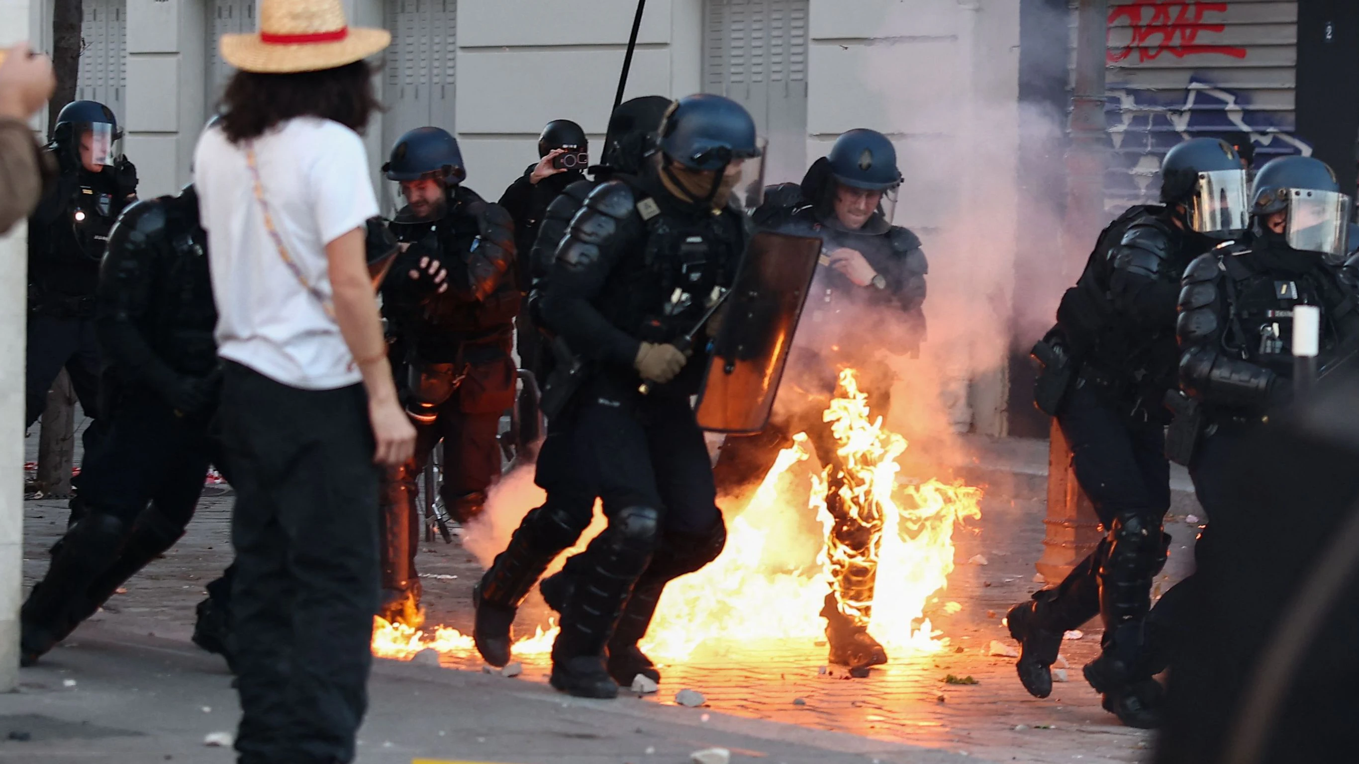 A French Gendarme who is partly burning runs in a street as facing protesters at the end of a protest march during nationwide demonstrations over the rising cost of living and inequality organised by Yellow Vest movement, labour unions and high school and university students, in Paris on October 31, 2026. "Exceptional" security deployment with 70,000 police officers and gendarmes mobilized and an alarmist tone: for Act III of the protests against the high cost of living, right in the middle of Halloween festivities, the authorities fear a repeat of the October 17 nightmare. France has been rocked by widespread anger over the rising cost of living and inequality. (Photo by Sameer AL-DOUMY / AFP)